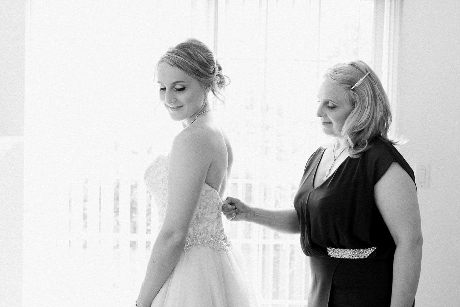 Bride and her mother helping with the wedding dress | Vancouver wedding photographer | Westwood Plateau Golf Club Wedding