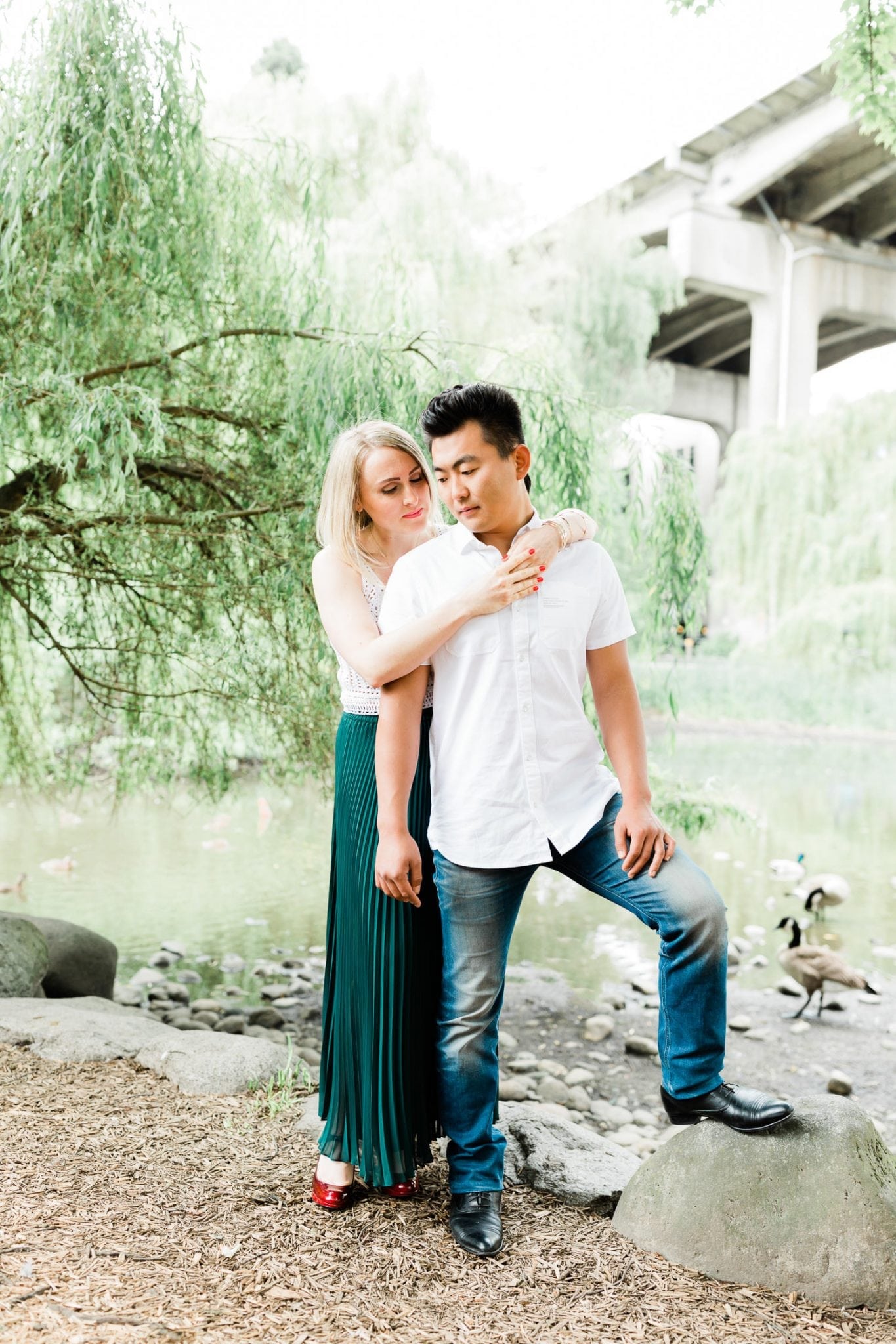 a couple posing by the pond on Granville Island during engagement photoshoot