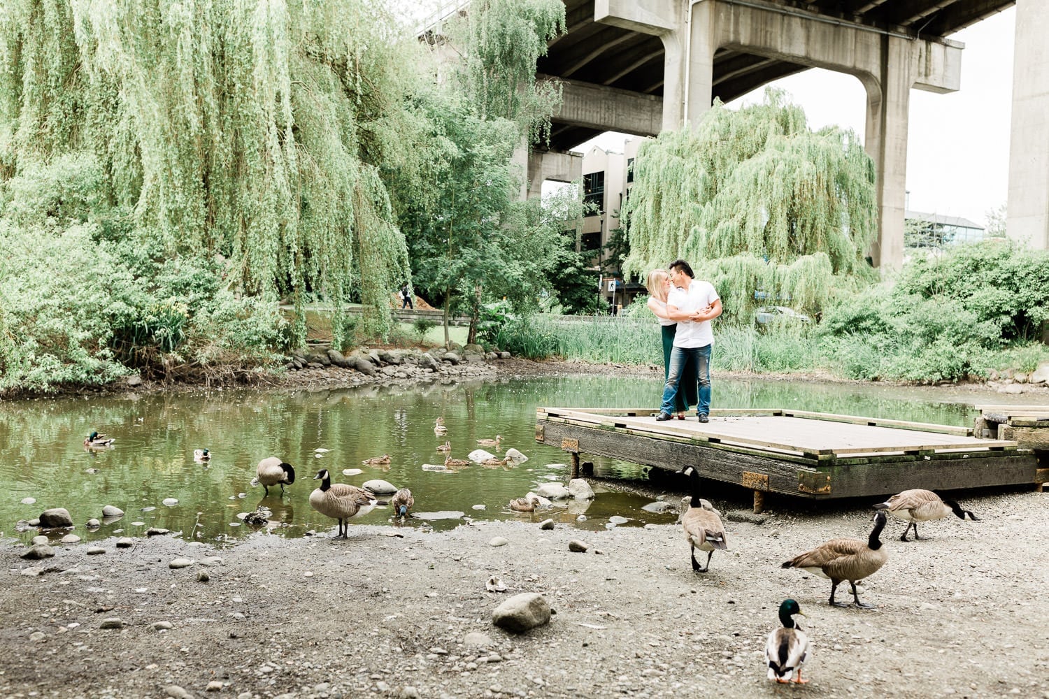 a couple posing by the pond on Granville Island during engagement photoshoot