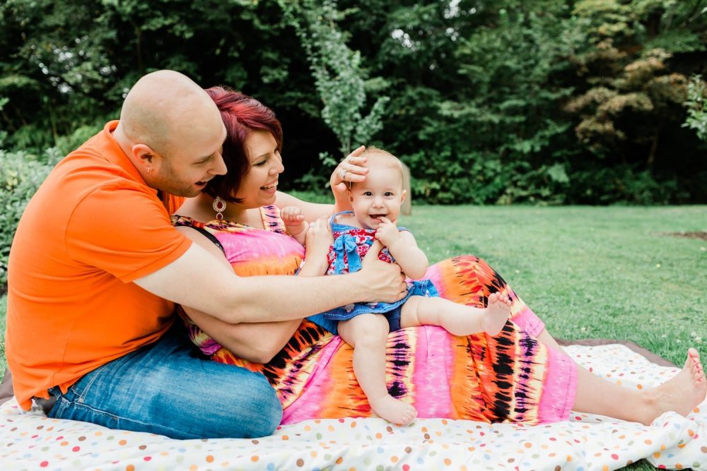 Couple sitting on the blanket holding a baby. Family Photo in Burnaby Village Museum